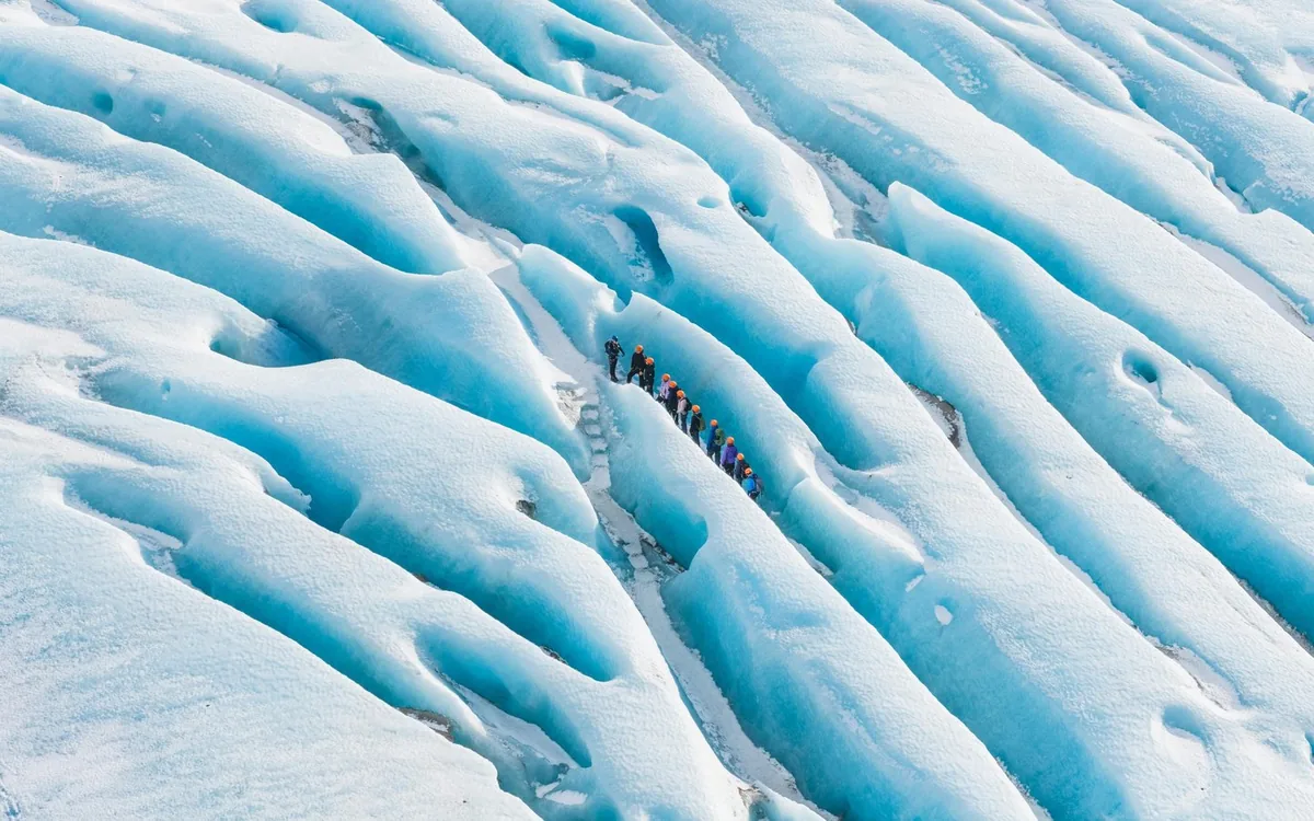 La superficie azul ondulada del hielo glaciar antiguo en Islandia