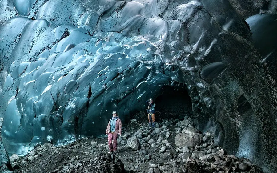 Una persona explorando una cueva de hielo azul dentro del glaciar Vatnajokull, Islandia