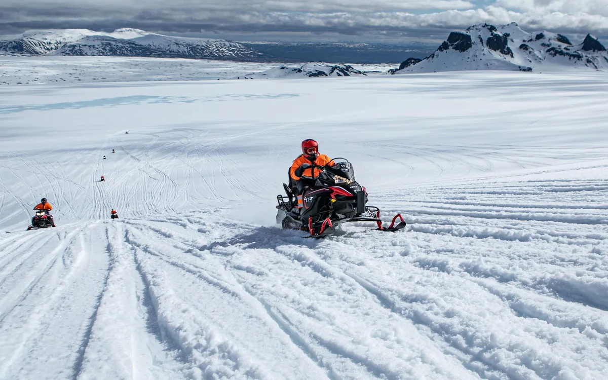 Ein Schneemobil überquert die weiße Oberfläche des Langjokull in Island