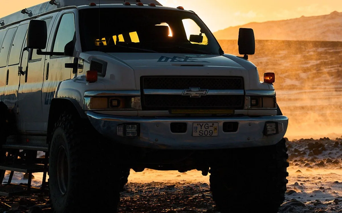 Un super jeep sur le sable volcanique noir devant un glacier dans le sud de l’Islande